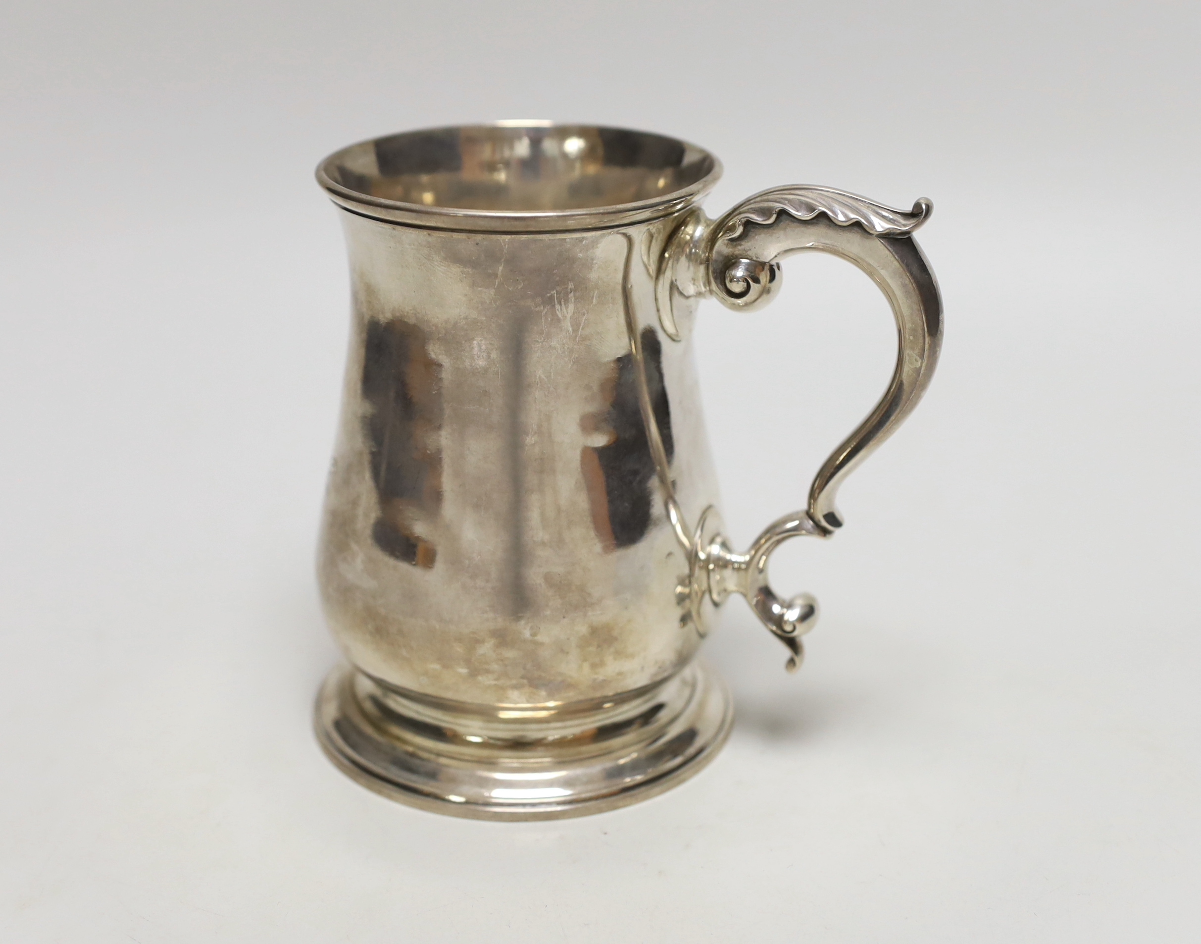 A George III silver baluster mug, with later monogram and acanthus scroll handle, makers initials FW, London 1775, 13cm, 372 grams
